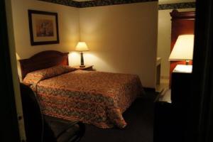 a hotel room with a bed and a lamp at Budget Inn in Waco