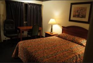 a hotel room with a bed and a desk at Budget Inn in Waco
