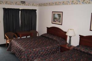 a hotel room with two beds and a table at Budget Inn in Waco