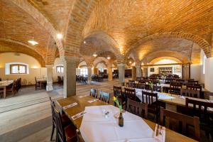 a dining room with tables and chairs in a building at Schlossparkhotel Mariakirchen in Arnstorf