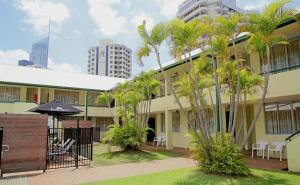 een gebouw met palmbomen ervoor bij Darcy Arms Hotel Motel in Gold Coast