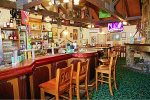 un bar con sillas de madera en un restaurante en Darcy Arms Hotel Motel en Gold Coast