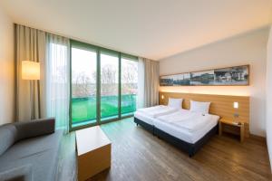 um quarto de hotel com uma cama e um sofá em Schlossparkhotel Mariakirchen em Arnstorf