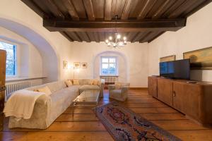 ArnstorfにあるSchlossparkhotel Mariakirchenのソファとテレビのあるリビングルーム