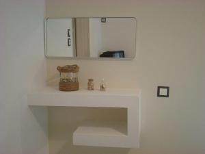 a bathroom with a mirror and a white sink at Smaragdi Studios and Rooms in Agios Kirykos +31 photos