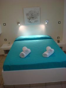 a bed with two towels on top of it at Smaragdi Studios and Rooms in Agios Kirykos