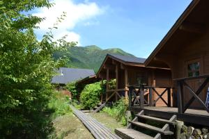 a log cabin with mountains in the background at Polan no Fue in Minamioguni