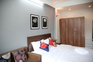 ein Schlafzimmer mit einem weißen Bett mit Kissen darauf in der Unterkunft V-Studio Apartment 2 in Hanoi