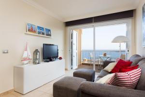 a living room with a couch and a tv at Vista al Faro in Poris de Abona