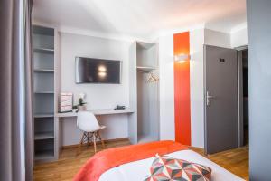 a small bedroom with a bed and a desk at Mandarina Hotel Luxembourg Strassen in Luxembourg