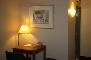 a room with a table with a lamp and a telephone at Emerald Inn in Maplewood