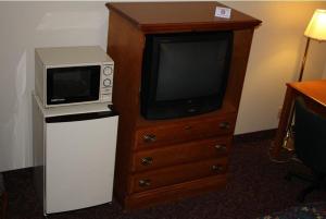 a microwave sitting on top of a wooden dresser at Emerald Inn in Maplewood
