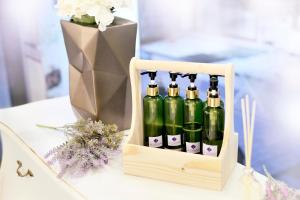 a crate of wine bottles on a table with a vase of flowers at De Lavender Bangkok Hotel in Bangkok