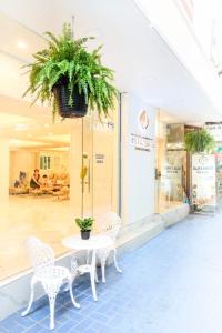 a table and chairs in front of a store at De Lavender Bangkok Hotel in Bangkok