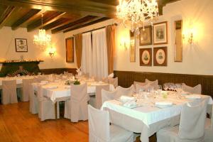 ein Esszimmer mit weißen Tischen und Stühlen sowie Kronleuchtern in der Unterkunft Hotel Boutique Balaitus in Sallent de Gállego