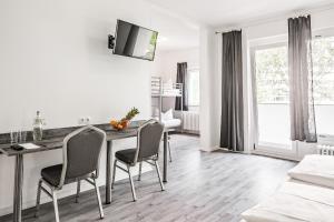 ein Wohnzimmer mit einem Esstisch und Stühlen in der Unterkunft Alecsa Hotel am Olympiastadion in Berlin