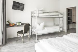 1 Schlafzimmer mit Etagenbetten, einem Schreibtisch und einem Stuhl in der Unterkunft Alecsa Hotel am Olympiastadion in Berlin