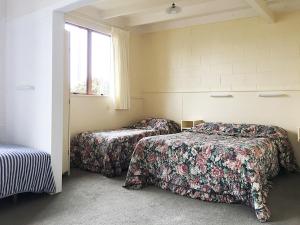 a room with two beds and a window at Martinborough Motel in Martinborough 