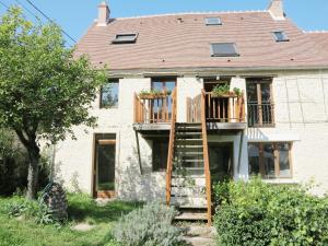 a house with a deck on the side of it at La Ferme des Acacias in Ormoy-la-Rivière