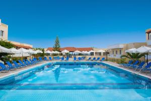 una gran piscina con sillas y sombrillas azules en Alexander House Hotel, en Agia Pelagia