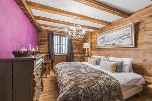 ヴァル・ディゼールにあるChalet Lièvre Blanc - LES CHALETS COVARELの大きなベッドとシャンデリアのある寝室