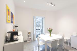 a white dining room with a table and chairs at Dimora CentroWell in Palermo