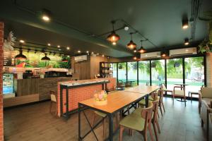 a restaurant with tables and chairs and a counter at Xen Hotel Nakhon Pathom - SHA PLUS in Nakhon Pathom