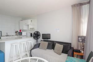 uma sala de estar com um sofá e uma cozinha em Chakas Cove 101 em Ballito