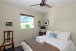 um quarto com uma cama e uma ventoinha de tecto em Chakas Cove 101 em Ballito