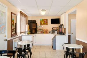 a room with two tables and a kitchen with a counter at Knights Inn - Park Villa Motel, Midland in Midland