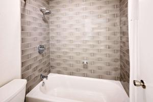 a bathroom with a white tub and a toilet at Howard Johnson by Wyndham Florence in Florence