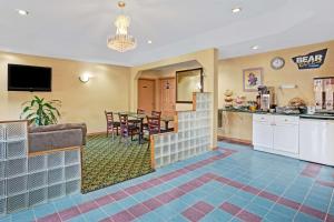 a living room with a kitchen and a dining room at Travelodge by Wyndham Forest Park Atlanta South in Forest Park