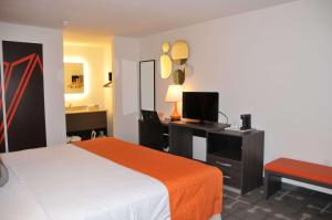 a bedroom with a bed and a desk with a computer at Howard Johnson by Wyndham Florence in Florence