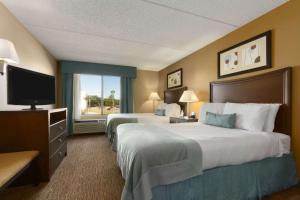 Habitación de hotel con 2 camas y TV en Wingate by Wyndham, Fayetteville NC, en Fayetteville
