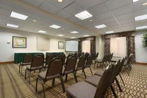 una sala de conferencias con sillas y una pantalla. en Wingate by Wyndham, Fayetteville NC en Fayetteville
