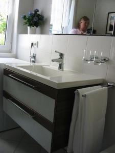 a bathroom with a sink and a person in the mirror at Symphonie-Villa am See - Musikerviertel in Konstanz