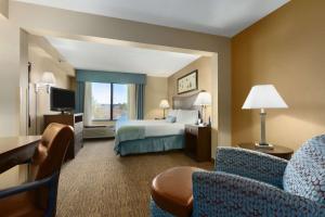 una camera d'albergo con letto e TV di Wingate by Wyndham, Fayetteville NC a Fayetteville