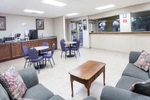 una sala de espera con sofás, mesa y sillas en Knights Inn Murfreesboro, en Murfreesboro