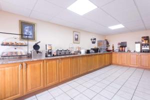 a large kitchen with wooden cabinets in a restaurant at Travelodge by Wyndham Chattanooga/Hamilton Place in Chattanooga