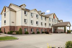 a large white building with a parking lot at Super 8 by Wyndham Perryville in Perryville