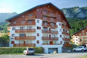 un gran edificio con coches estacionados en un estacionamiento en Appartement Yeti Immobilier 1, en Thollon-les-Mémises