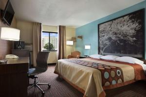 a hotel room with a large bed with a desk and a desk at Super 8 by Wyndham Mount Vernon, IL in Mount Vernon