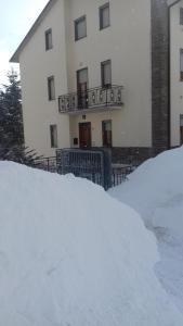 un cumulo di neve di fronte a un edificio di Appartamento Montefumaiolo a Balze