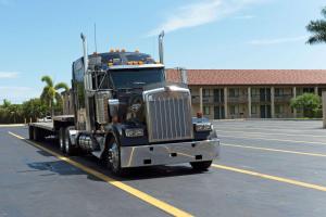 a semi truck is parked in a parking lot at Super 8 by Wyndham Riviera Beach West Palm Beach in Riviera Beach