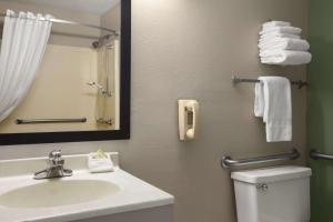 a bathroom with a sink and a mirror and a toilet at Super 8 by Wyndham Batesville in Batesville
