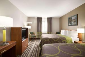 a hotel room with two beds and a flat screen tv at Super 8 by Wyndham Bozeman in Bozeman