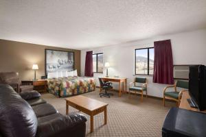 a hotel room with a couch and a bed at Super 8 by Wyndham Bozeman in Bozeman