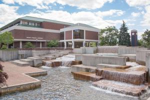 a building with a water fountain in front of a building at Super 8 by Wyndham Sheboygan WI in Sheboygan