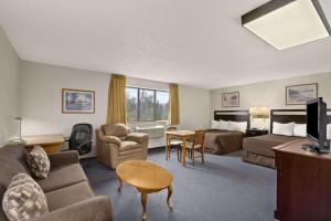 une chambre d'hôtel avec un lit et un salon dans l'établissement Super 8 by Wyndham Williams Lake BC, à Williams Lake