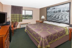 a hotel room with a bed and a flat screen tv at Super 8 by Wyndham Anamosa IA in Anamosa